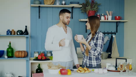 una pareja tomando café en la cocina.
