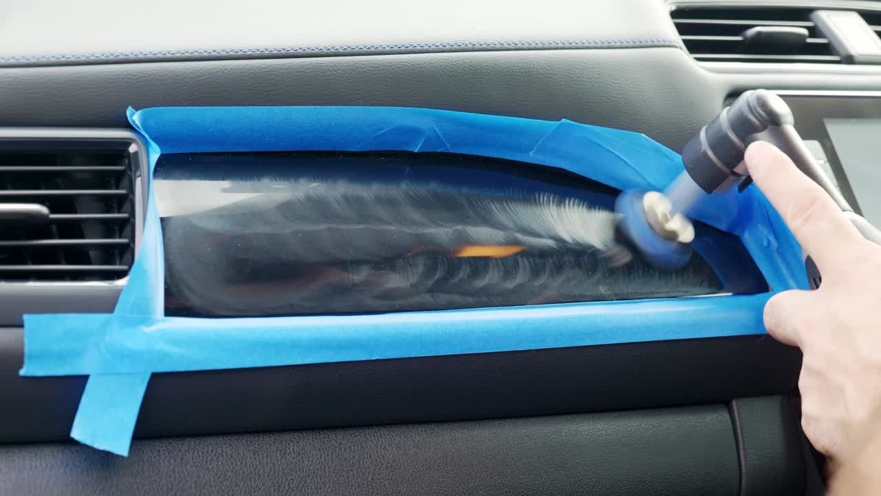 Polishing interior piano black trim inside car above glove box