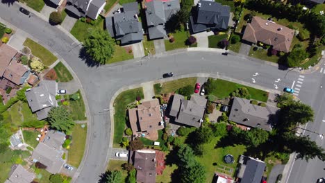 el coche azul sale del barrio de seattle hacia la carretera principal - imágenes de drones aéreos - coche de seguimiento directo hacia abajo - comienzo de vacaciones y viaje por carretera