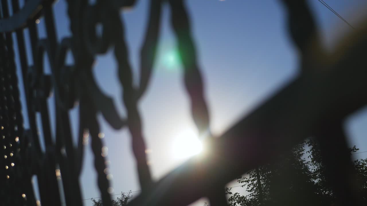 солнечный блеск через железные ворота