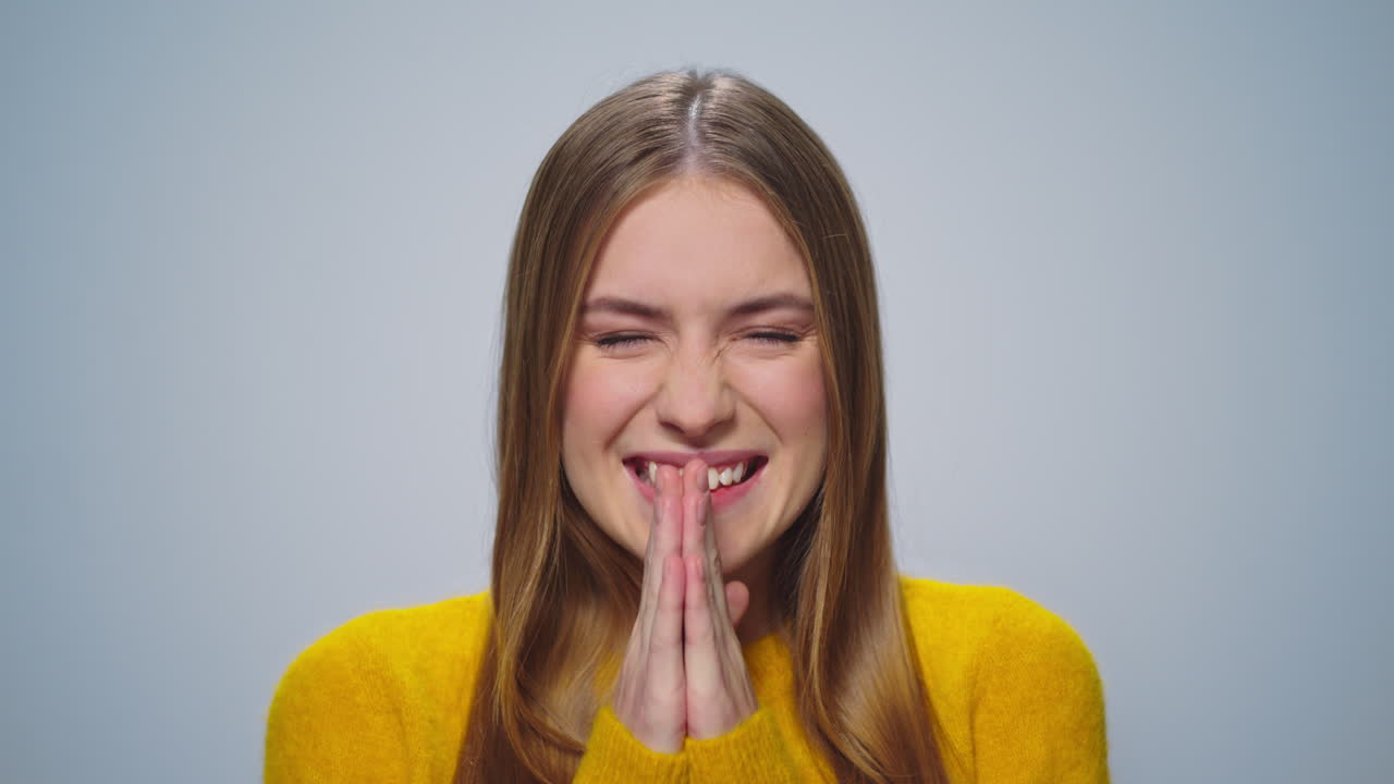 회색 배경에 카메라를 향해 미소 짓는 행복한 매력적인 여성의 초상화.