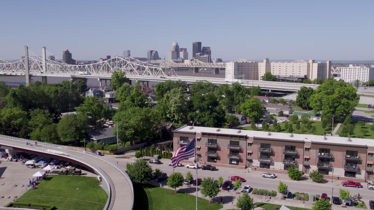 Aerial footage of the Louisville, Kentucky skyline with the walking bridge in view on a bright sunny day. Perfect for travel, tourism, and cityscape content.