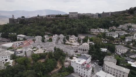 órbita aérea sobre el casco antiguo de la ciudad de gjirokaster con el castillo de fondo, albania