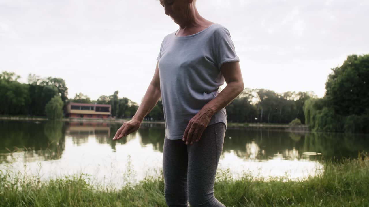vista panorámica de una mujer mayor practicando yoga al atardecer