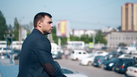 close view man in jacket sits near parking lot in town