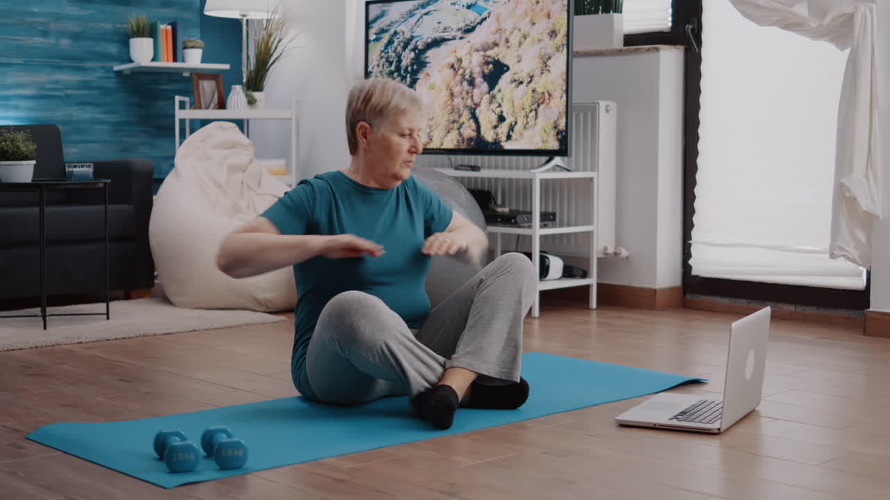 Old person looking at video with workout lesson on laptop