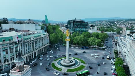 Toma-De-Drones-Para-La-Plaza-De-La-Libertad-En-Tbilisi,-Georgia,-Por-La-Tarde-Antes-De-La-Puesta-De-Sol-Al-Final-De-La-Primavera-Y-El-Comienzo-Del-Verano,-Cuando-Los-árboles-Se-Ven-Verdes.