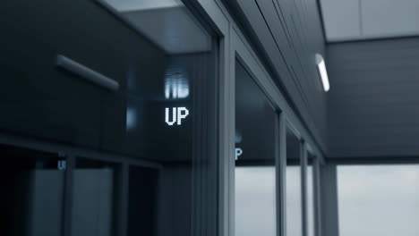 digital 'up' sign reflected on an elevator door
