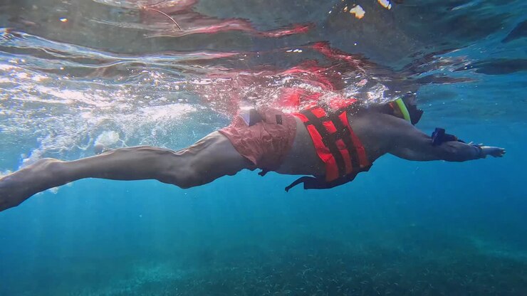 Uomo che fa snorkeling nelle acque del Mar dei Caraibi.