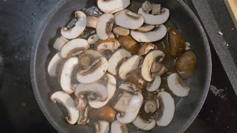 top down view up of fresh sliced mushrooms cooking in a pan for a delicious healthy recipe