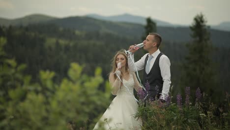 groom with bride drink champagne on a mountain hills. wedding couple. family