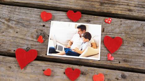 Red-heart-and-photograph-on-wooden-plank