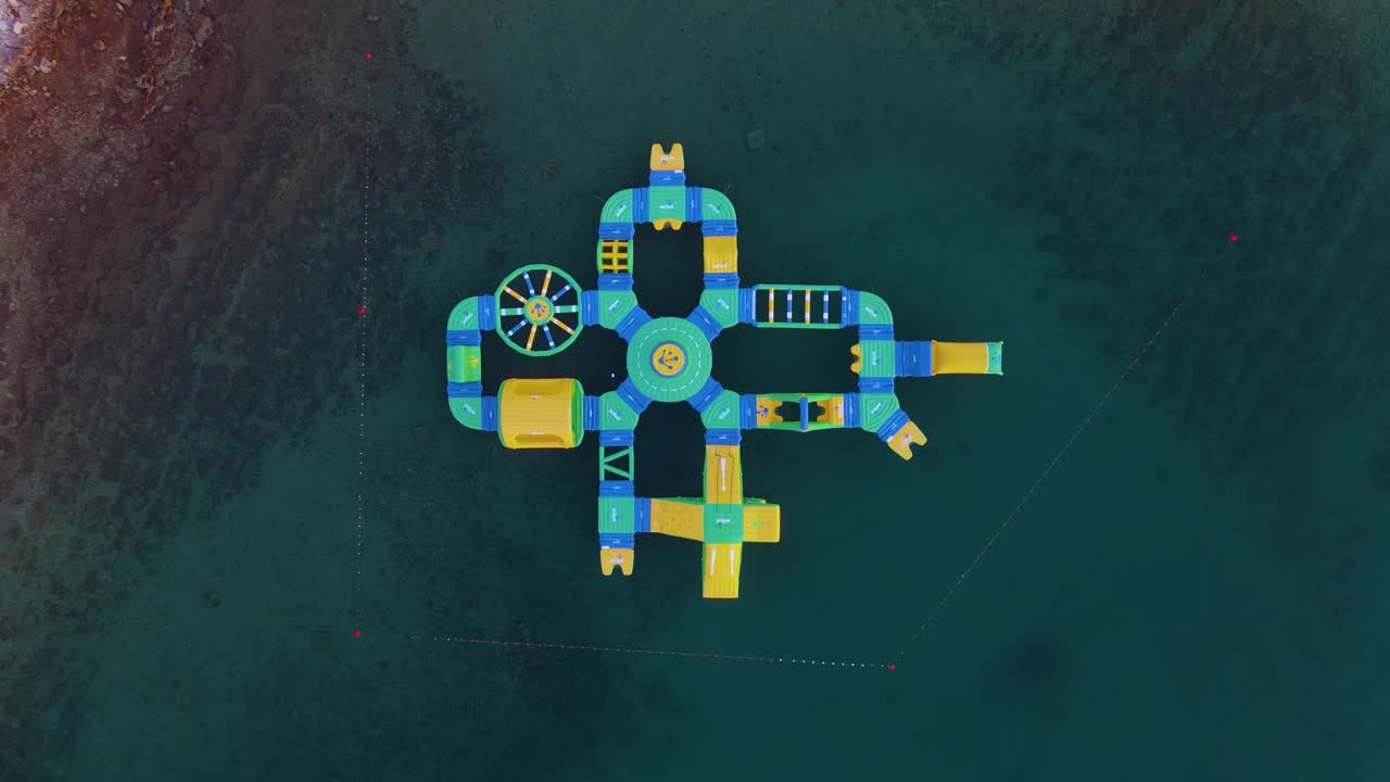 드론 감시를 통해 해변에 연결된 부풀어 오르는 워터 파크의 공중 전망