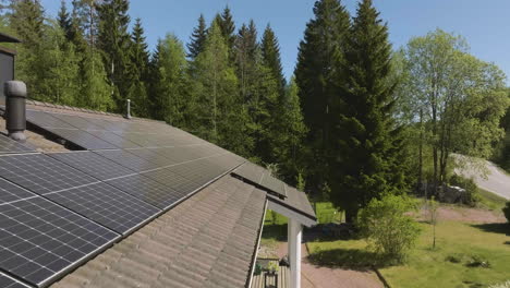 Drone tilting over a house powered with solar power, on a vibrant spring day