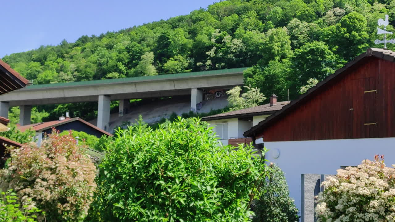 Freeway in-between homes and trees, A 59 in Southern Germany. Truck crossing the bridge.