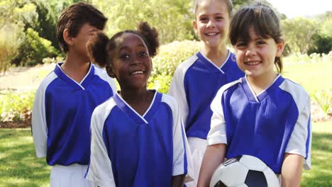 group of smiling kids standing with football