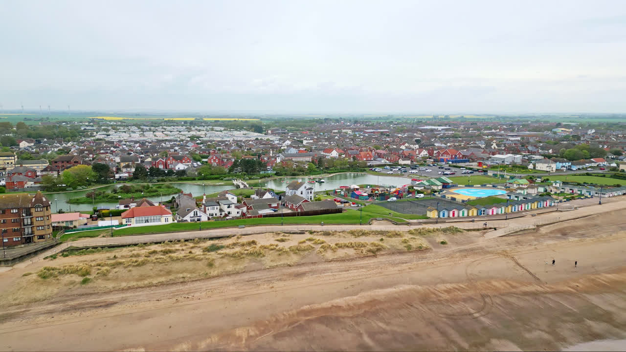 Aerial glimpses of Mablethorpe, Lincolnshire's east coast retreat, showcasing beach huts, sandy beaches, amusement parks, rides, and tourists