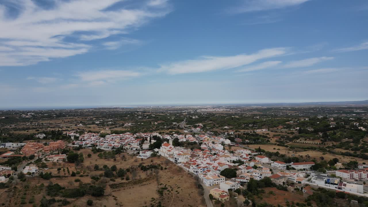 Ampio filmato aereo con drone che sorvola un paesaggio arido e la bellissima città di Porches nell'Algarve, Portogallo