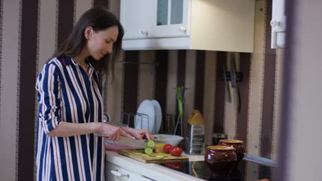 mujer cortando verduras en una cocina