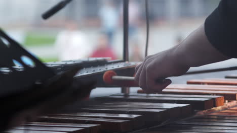 street performer playing percussion instrument on rainy day