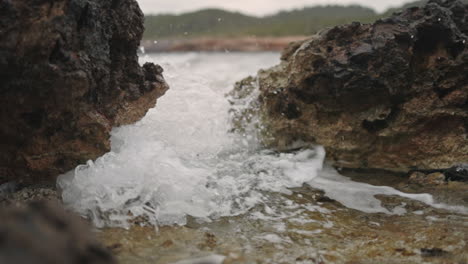 Wellen,-Die-Zwischen-Felsen-Am-Strand-Brechen,-Zeitlupen-Mittelaufnahme