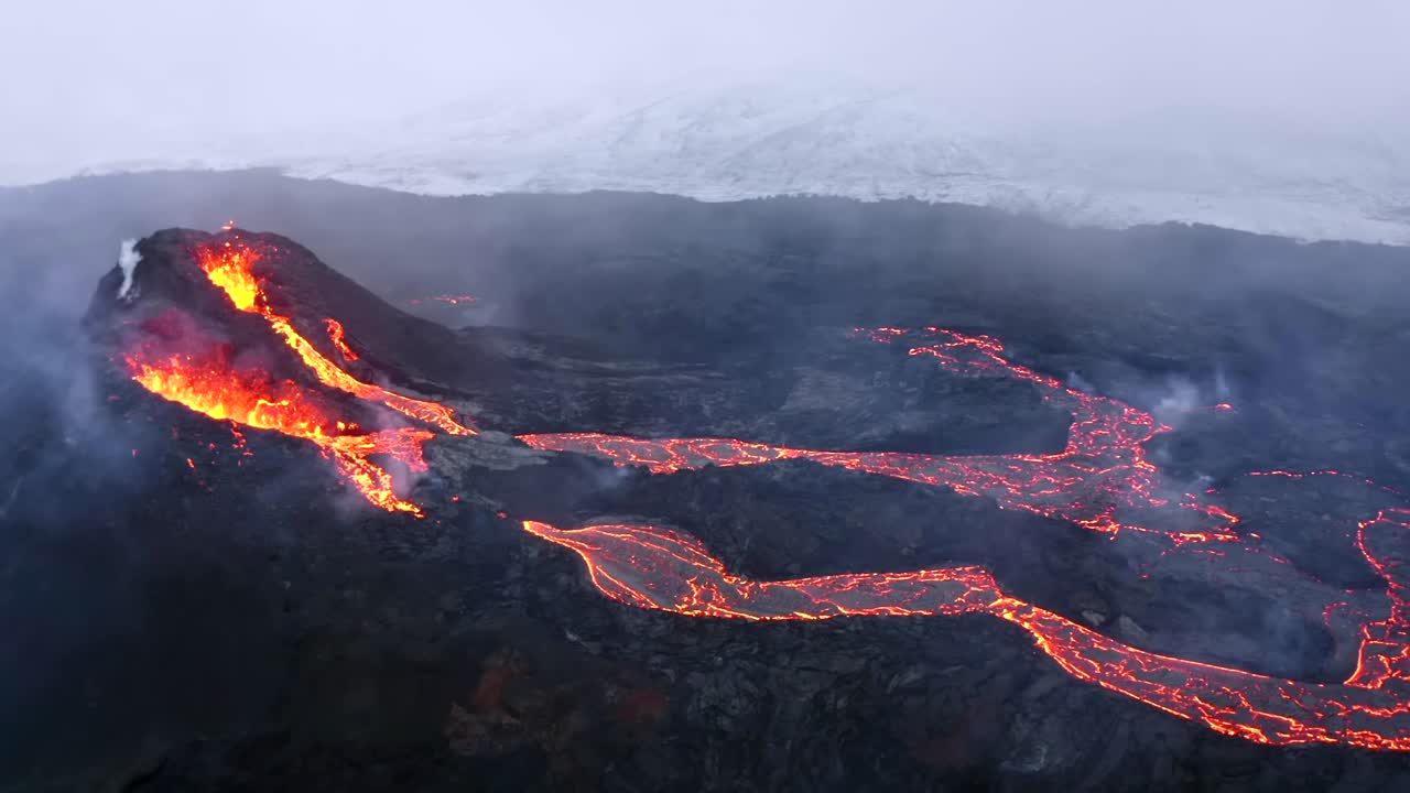 Aerial cinematic shots captured by a 4K drone depict a landscape of volcanic fields with flowing lava and swirling smoke