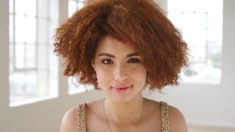 Portrait-of-a-trendy-redhead-woman-standing-inside