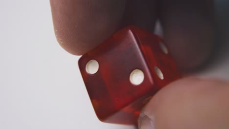 man-shows-bright-red-dice-with-spots-on-light-background