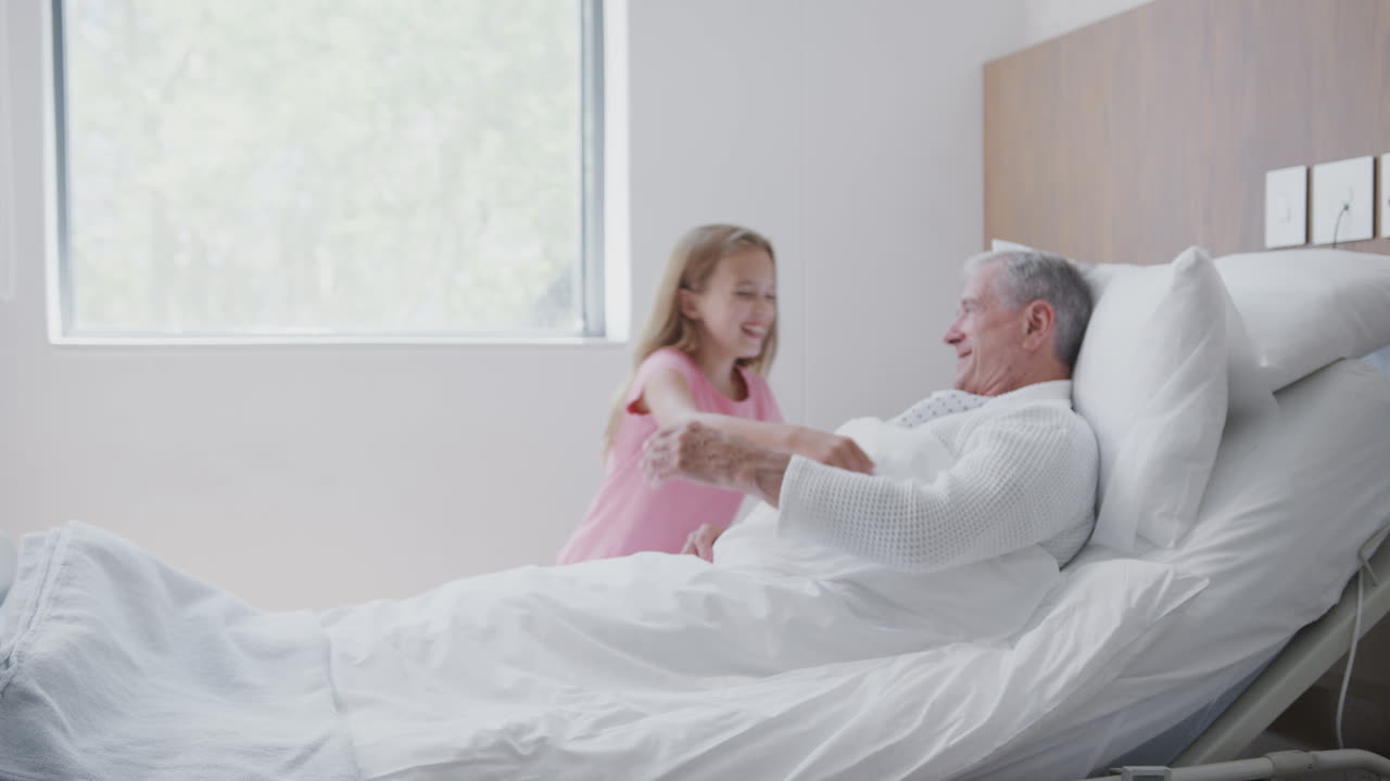 retrato de una niña acostada en la cama en la sala del hospital abrazando a un oso de peluche