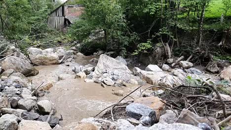 Verheerender-Fluss-In-Zeitlupe-Mit-Altem-Haus-In-Der-Nähe