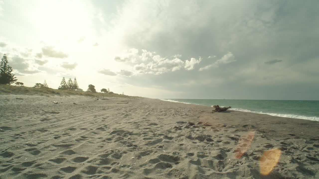 nubes celestiales iluminadas por el sol sobre la playa de arena y las olas del mar esmeralda