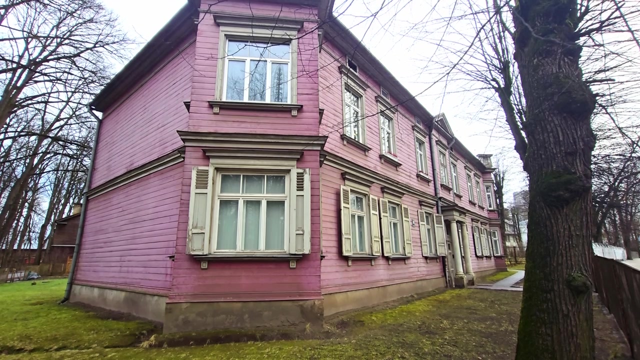Vecchia casa di legno rosa situata in una strada dello storico quartiere di Agenskalns, Riga.