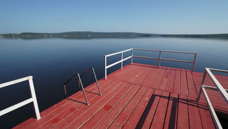 un muelle de madera roja en un lago tranquilo