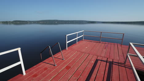 red wooden dock on a calm lake