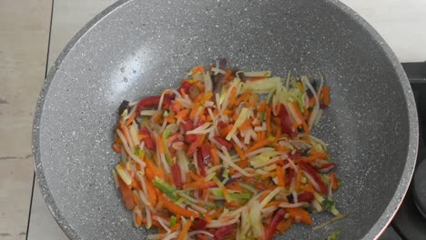 woman's hand lifting the lid from the wok