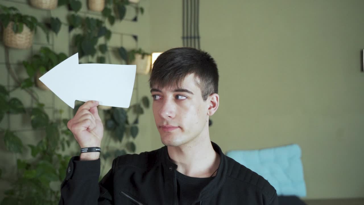 설명하기 위해 누군가에게 화살표를 가리키는 젊은 검은 머리 남성 유럽 학생