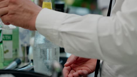 cerca de un camarero mezclando un cóctel de ginebra de limón con hielo y una guarnición
