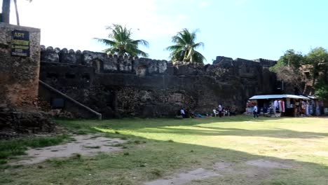 Old-fort-of-Zanzibar-with-grassy-courtyard-houses-local-curiosity-stores,-Stone-Town