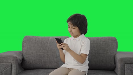 Feliz-Niño-Indio-Charlando-Con-Alguien-En-La-Pantalla-Verde-Del-Teléfono