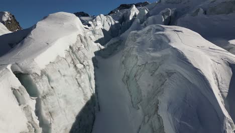 Icy-snow-covered-glacier-in-the-Swiss-alps,-mountains-in-high-altitude,-aerial-view