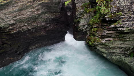 Drone-descends-into-a-cave,-close-to-the-craggy-walls