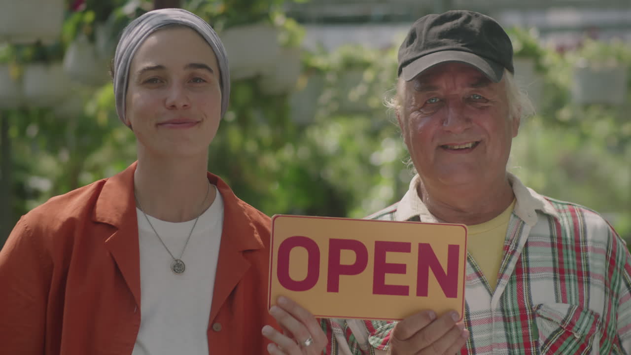 Portrait of Coworkers with Open Sign in Plant Nursery