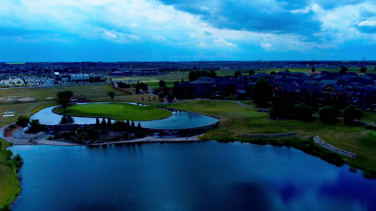 golfbaan naast vrijstaand groot huis gemeenschap met kunstmatige greens vijver goed ontworpen tuinen watervallen luchtviaduct zomerdag reflectie op het wateroppervlak wolken die privépad tonen
