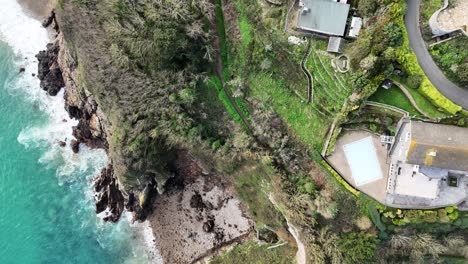 Imágenes-Aéreas-De-Guernsey-Fort-George-De-Casas-En-Lo-Alto-De-Un-Acantilado-En-Una-De-Las-Urbanizaciones-Más-Caras-De-Guernsey-Con-Casas-De-Mercado-Abierto,-Jardines,-Acantilados,-Orilla-Del-Mar-Y-Sus-Alrededores-En-Un-Día-Soleado