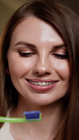 mujer con aparatos dentales cepillándose los dientes