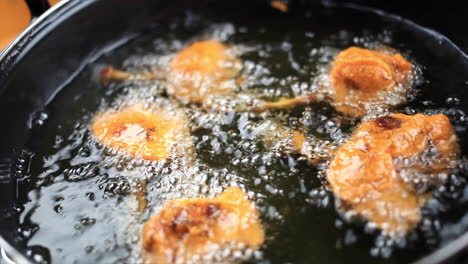 non vegetarian restaurant style chicken lollipop frying in sizzling hot oil, slow motion cooking video