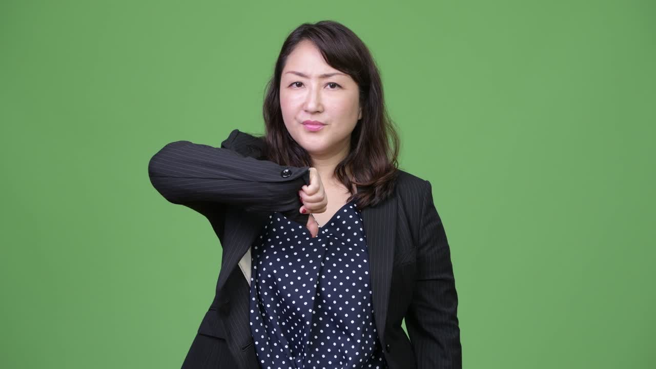 Mature beautiful Asian businesswoman giving thumbs down