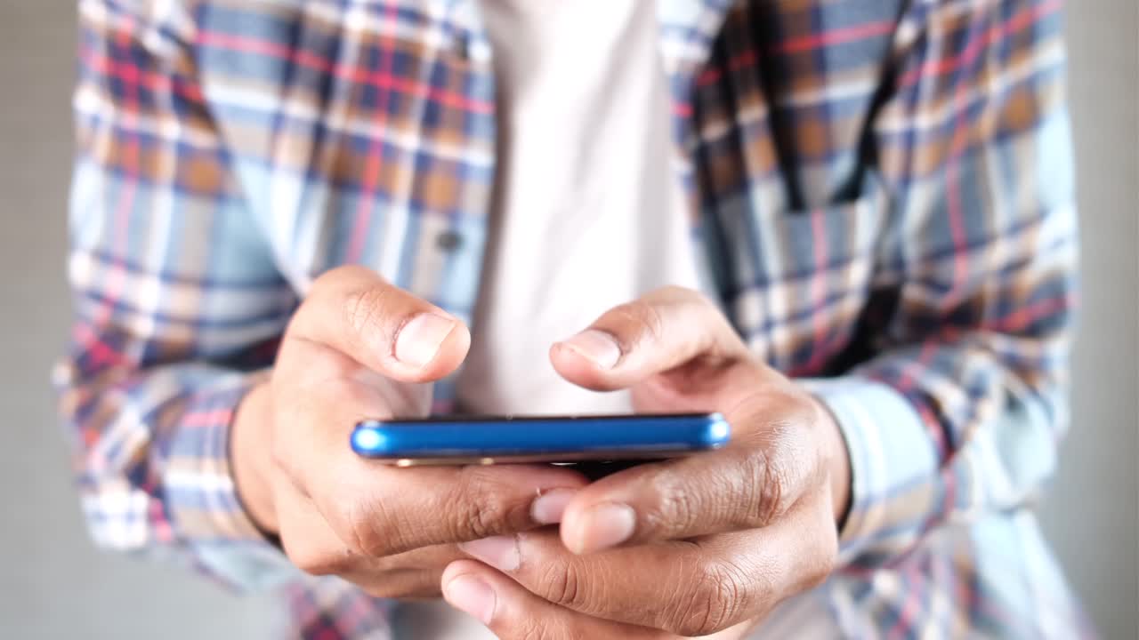 hombre usando un teléfono inteligente azul