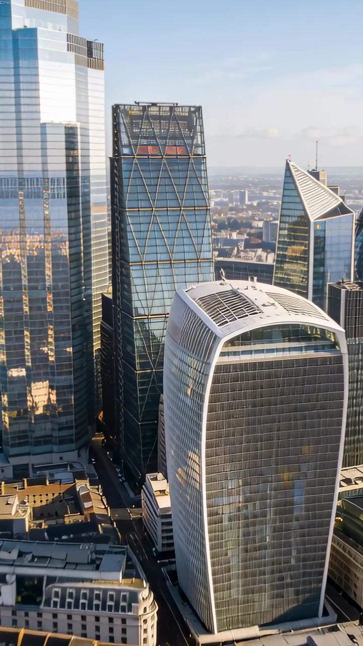 Video verticale: Drone che avanza, rivelando una torre di vetro curva in centro per mostrare l'impianto di climatizzazione sul tetto.