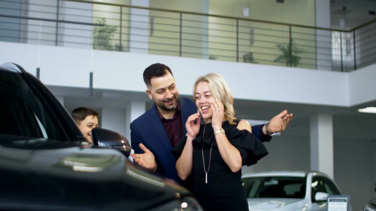 familia feliz consiguiendo un coche nuevo en el salón